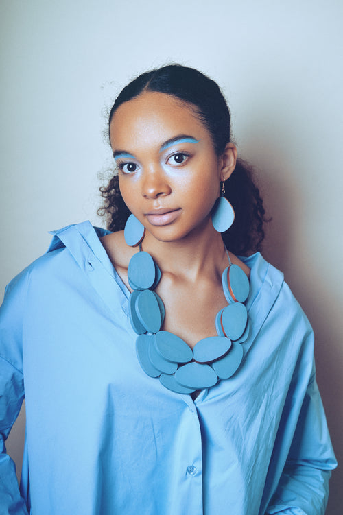 Bananas statement wooden necklace made of blue wooden letters in a set together with matching earrings made of wood with bronze rim.